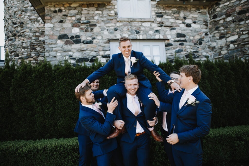 Groomsmen holding up groom